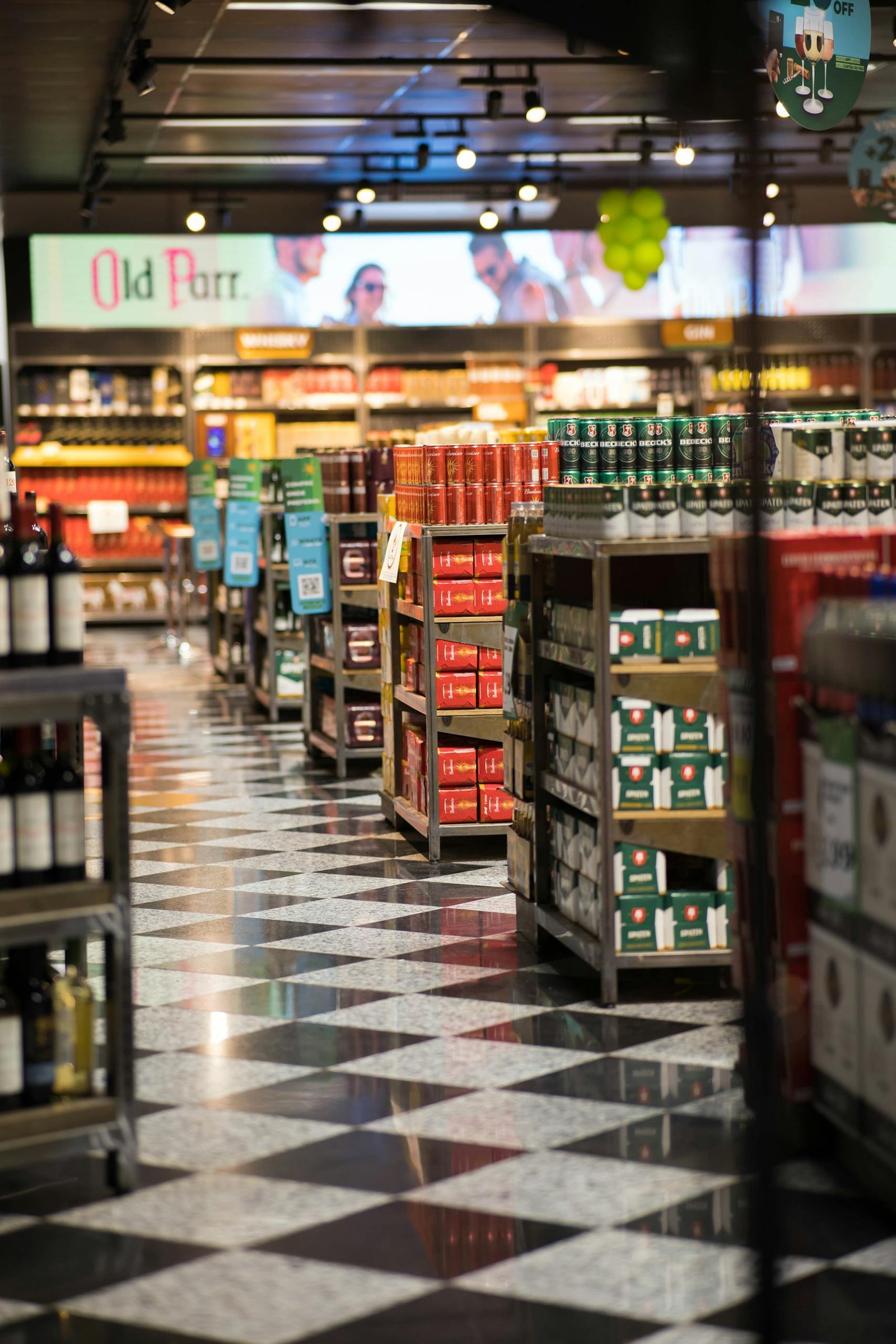 A quiet evening in a grocery store with neatly stacked products and checkered floors.